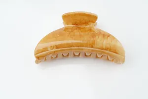 Primer plano detallado de pinza para el cabello marrón carey, textura lisa y dientes fuertes.