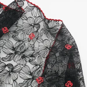 Black lace floral triangular scarf with red embroidered monogram trim and elegant design.