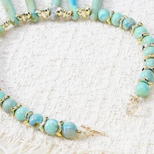 Collier de perles turquoise bohême avec entretoises dorées et fermoir toggle élégant.