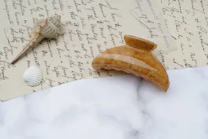 Detalle de pinza de pelo de mármol marrón, pinza mediana elegante para coletas elegantes.
