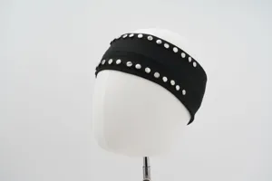 Close-up of black wide headband with double-row metal rivets on white mannequin head.