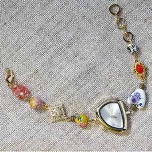 Gold irregular triangle dial women quartz watch with handmade ceramic enamel beaded charm bracelet.
