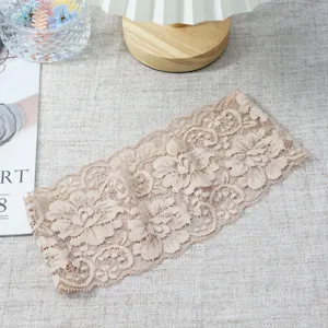 Close-up detail of the wide lace hairband, showcasing delicate floral patterns and elastic texture.