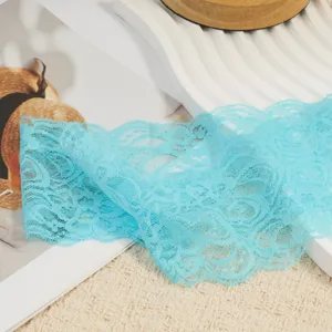 Light blue elastic lace trim close-up, delicate hollow floral pattern for DIY sewing & crafts.