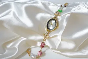 Details of vintage gold quartz watch with pearls, floral glass beads and sparkling rhinestones.