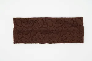 Dettaglio fascia per capelli in pizzo marrone, fascia yoga elastica, accessorio retrò.