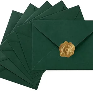 Conjunto de sobres verde oscuro con elegante sello de cera dorada para invitaciones de boda y tarjetas