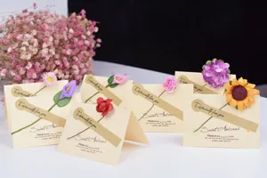 Primer plano de tarjetas de felicitación artesanales en papel kraft con delicadas flores secas.