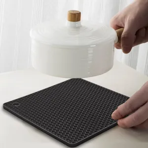 Tapis isolante thermique en silicone noir à motif alvéolé pour table de cuisine anti-brûlure.