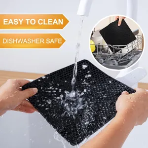 Gros plan d'un dessous de plat en silicone noir lavé sous l'eau, compatible lave-vaisselle.