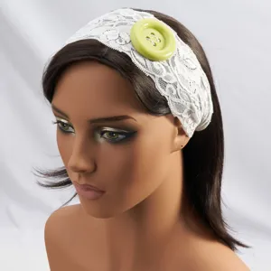 Gedetailleerd overzicht van de witte kanten haarband met grote groene knopversiering.