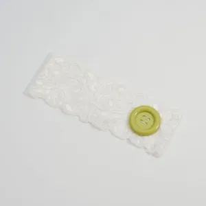 Witte kant hoofdband met een grote groene knop, stijlvol elastisch haar accessoire.