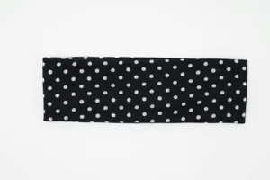 Closeup view of the black and white polka dot knitted wide headband texture and details.