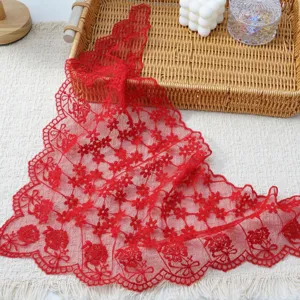 Red lace triangle scarf detail view with delicate floral embroidery and elegant wavy edges.