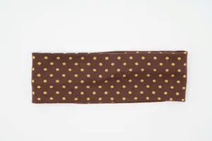 Detailed view of brown polka dot wide knit headband, elastic fabric for women daily wear.