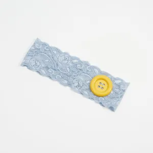 Close-up detail van lichtblauwe kanten haarband met gele grote knop, elastisch haaraccessoire.