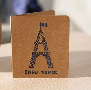 Gros plan d'une carte de voeux vintage en papier kraft brun avec une tour Eiffel decoupee.
