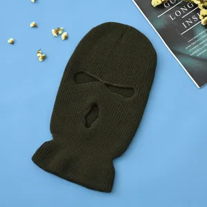 Dettaglio di passamontagna in maglia verde scuro, morbida maschera da sci con aperture.