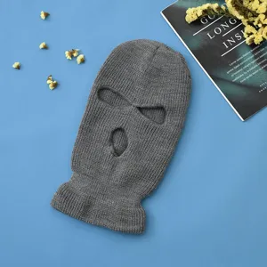 Vista dettagliata del passamontagna in maglia grigia, che mostra consistenza e design a tre fori.