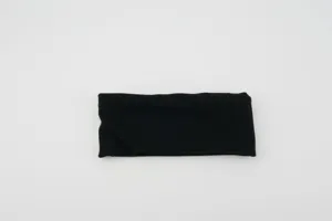 Close-up detail of black elastic sports headband, thick wide fabric, solid color hair accessory