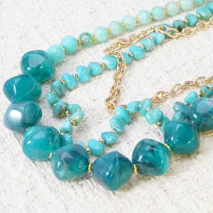 Prachtige close-up van een meerstrengs turquoise kralen en gouden ketting detail.