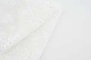 Witte kant haarband stof detail opname, elegante holle bloem motief textuur close up.