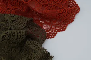 Gedetailleerde close-up van kleurrijke kantstof met fijn opengewerkt bloemenpatroon.