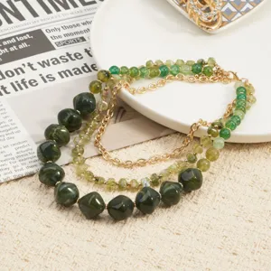 Elegante meerlaagse groene kralenketting met gouden kettingen, boheemse stijl sieraden detail.