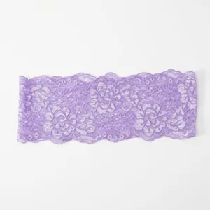 Nahaufnahme von lila elastischer Blumenspitze mit feinem durchbrochenem Blumenmuster.