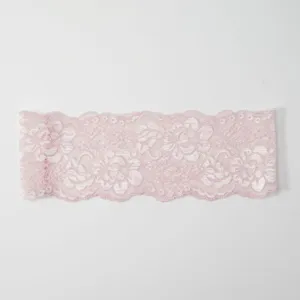 Nahaufnahme des eleganten rosa elastischen Spitzen-Haarbands mit zartem Blumen-Hohlmuster.