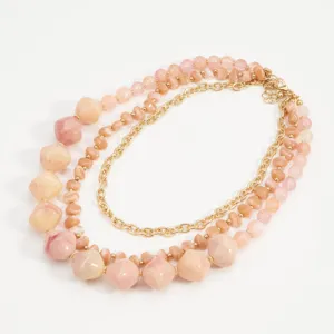 Gedetailleerd overzicht van de meerstrengs boho roze kralen en goudketting ketting, sieraden.
