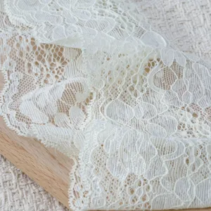 Weisse spitzenbesatz stoff detail, exquisite hohle blumenmuster fuer diy naehen.