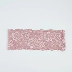 Nahaufnahme der rosa elastischen Spitzenborte mit feinem Blumenmuster und zarter Webstruktur.