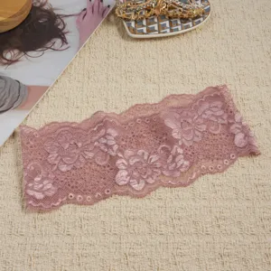 Detailansicht des eleganten rosa elastischen spitzenstirnbandes mit zarten hohlen blumenmustern.