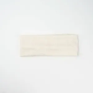 Detailed view of beige knitted paisley headband, soft elastic hair accessory for women.