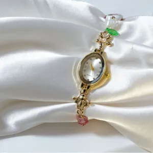 Elegant women quartz watch with gold oval dial, sparkling rhinestones and beaded pearl bee strap.
