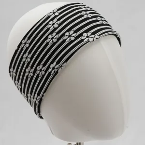 Gros plan sur un bandeau de yoga élastique rayé noir et blanc avec un motif en tricot floral.