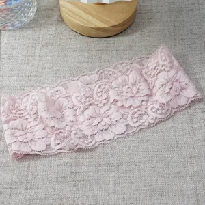 Pink wide lace floral headband detail shot, elegant stretchy hollow hair accessory for women.