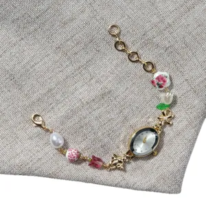 Vintage oval quartz watch for women with pearls and floral beads charm bracelet style.