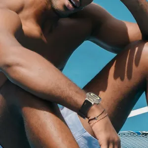 Detailed close-up shot of rugged silicone watch strap and protective case worn on wrist outdoors.