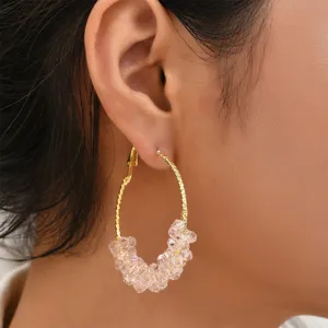Gros plan détaillé des boucles d'oreilles élégantes à cristaux roses scintillants.