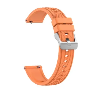 Detail shot of orange silicone smartwatch strap with silver quick release buckle and textured design.