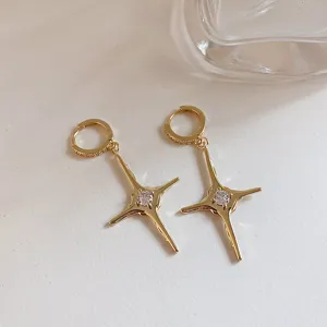 Detailed close-up view of trendy gold-plated four-pointed star hoop earrings with sparkling zircon.