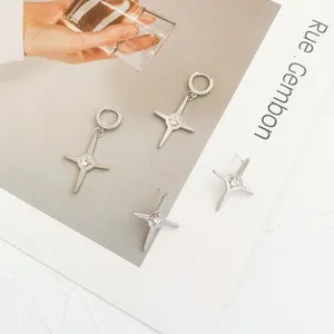 Detailed view of trendy four-pointed star zircon earrings and hoop set, stylish design.
