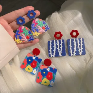 Nahaufnahme Detailansicht farbiger Acryl geometrischer Blumen Ohrringe modisches Accessoire.