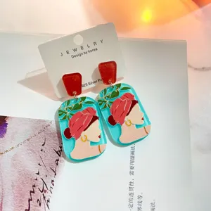 Detailaufnahme der Acryl-Ohrringe im Detail mit kreativem Frauenporträt und geometrischem Design.