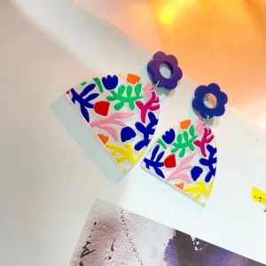 Kreative Acryl geometrische Ohrringe mit bunten abstrakten Mustern und lila blumen.