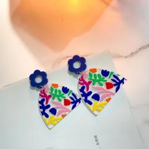 Bunte geometrische Acryl Ohrringe mit blauer Blume oben und transparentem fächerförmigen Anhänger.