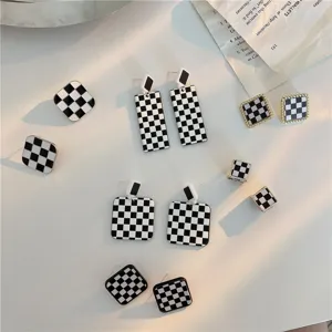 Detailed view of vintage black and white checkerboard geometric earrings with silver pins.