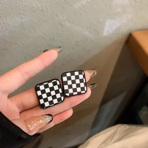 Black and white checkerboard geometric stud earrings, vintage retro chic design jewelry.